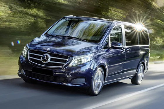 Luxury Mercedes van for easy shuttle transportation on beautiful road.