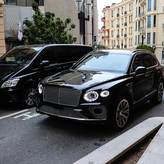 Luxury vehicles parked on a city street, ideal for event transportation options and services.